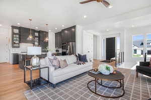 Living room featuring ceiling fan and light hardwood / wood-style flooring