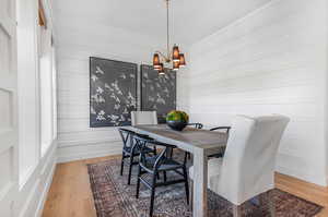 Dining area with an inviting chandelier, hardwood / wood-style flooring, and crown molding