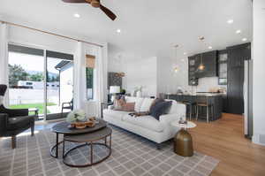 Living room featuring light hardwood / wood-style floors, a healthy amount of sunlight, and ceiling fan