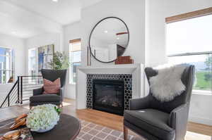 Living room featuring a tiled fireplace and light wood-type flooring