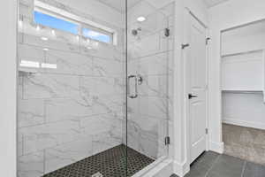 Bathroom featuring tile flooring and a shower with door