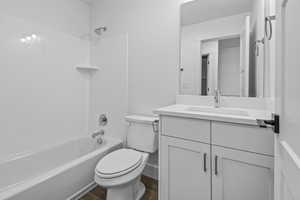 Full bathroom with hardwood / wood-style flooring, shower / washtub combination, toilet, and vanity with extensive cabinet space