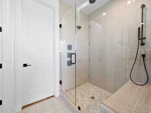 Bathroom featuring tile patterned flooring and a shower with door