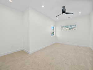 Spare room with ceiling fan and light colored carpet