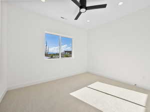 Carpeted spare room featuring ceiling fan