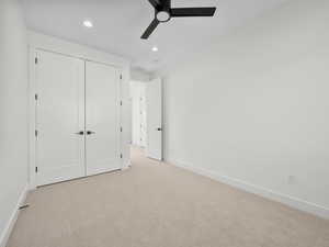 Unfurnished bedroom with a closet, ceiling fan, and light carpet