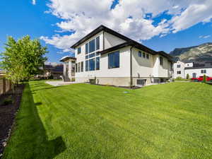 Back of property with a patio, cooling unit, and a lawn