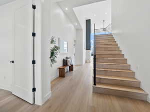 Stairway featuring a towering ceiling and wood-type flooring