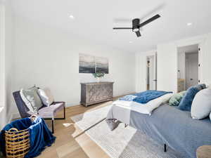 Bedroom featuring light hardwood / wood-style flooring, ceiling fan, and ensuite bathroom