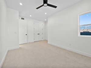 Unfurnished room featuring light colored carpet and ceiling fan