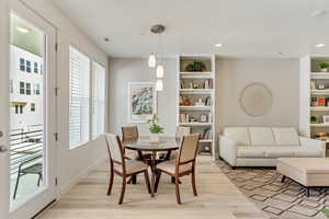 Dining room featuring a wealth of natural light, built in shelves, and light wood-type flooring