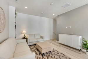 Living room featuring light hardwood / wood-style floors and a textured ceiling