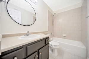 Full bathroom with shower / bathtub combination with curtain, vanity, and toilet