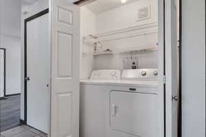 Clothes washing area with washer and clothes dryer and light hardwood / wood-style floors