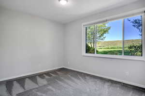 Empty room featuring dark colored carpet