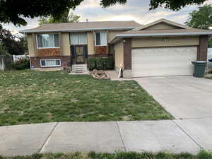 View of front of home with a front lawn and a garage