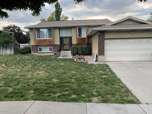 View of front of property with a garage and a front yard