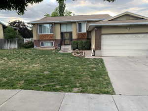 View of front of home with a garage and a front lawn