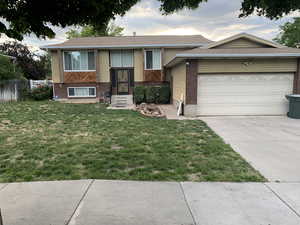 View of front of home featuring a garage and a front lawn