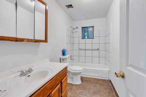 Full bathroom featuring tile flooring, tiled shower / bath combo, vanity, and toilet