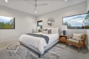 Bedroom with ceiling fan, multiple windows, and carpet floors