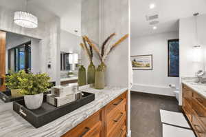 Bathroom featuring a chandelier, tile flooring, vanity, and toilet