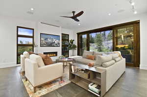 Tiled living room featuring plenty of natural light, ceiling fan, and rail lighting