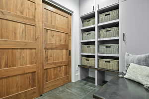 Mudroom with dark tile flooring