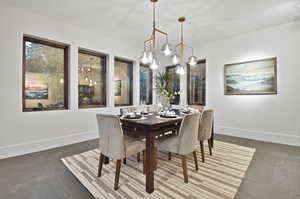 Dining space with dark tile flooring and a chandelier