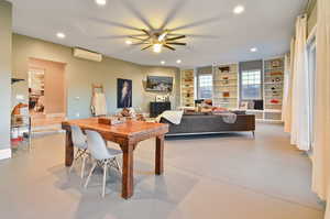 Dining area featuring a wall unit AC and ceiling fan