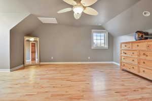 Bedroom with lofted ceiling, light wood-type flooring, and ceiling fan