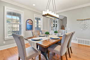 Dining room featuring plenty of natural light, light hardwood / wood-style flooring, and crown molding