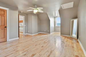 Additional living space featuring vaulted ceiling, ceiling fan, and light hardwood / wood-style floors