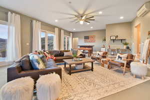 Living room with ceiling fan and an AC wall unit