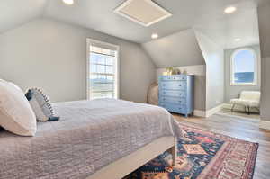 Bedroom featuring wood-type flooring and vaulted ceiling