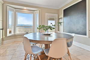 Dining space with crown molding and light tile floors