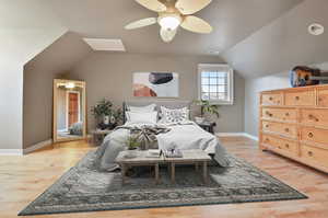 Bedroom with ceiling fan, vaulted ceiling, and light hardwood / wood-style flooring