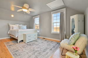 Bedroom with ceiling fan, lofted ceiling, and wood-type flooring