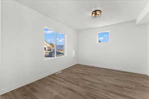 Unfurnished room with dark wood-type flooring