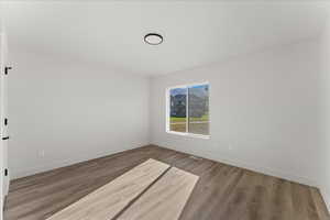 Empty room with hardwood / wood-style flooring