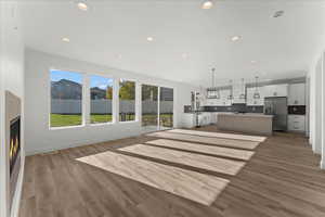 Unfurnished living room featuring hardwood / wood-style floors and a wealth of natural light