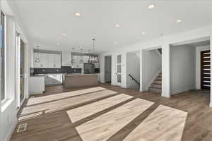 Kitchen with a center island, tasteful backsplash, stainless steel fridge, and light wood-type flooring