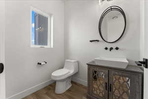 Bathroom featuring wood-type flooring, vanity, and toilet