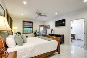 Master Bedroom featuring ceiling fan, ensuite bathroom, and light tile floors