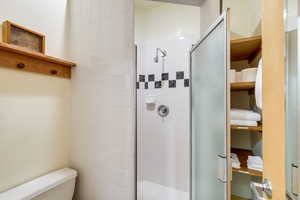 Bathroom featuring an enclosed shower and toilet