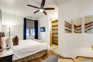 Bedroom featuring ceiling fan, hardwood / wood-style flooring, and a spacious closet