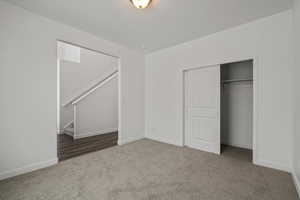 Unfurnished bedroom featuring a closet and dark colored carpet