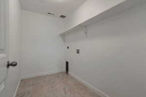 Laundry area with hookup for a washing machine, electric dryer hookup, and light tile floors