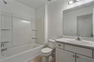 Full bathroom with tile flooring, vanity, toilet, and shower / bathing tub combination