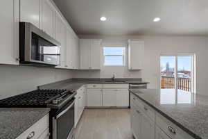 Kitchen with sink, white cabinets, a wealth of natural light, and appliances with stainless steel finishes